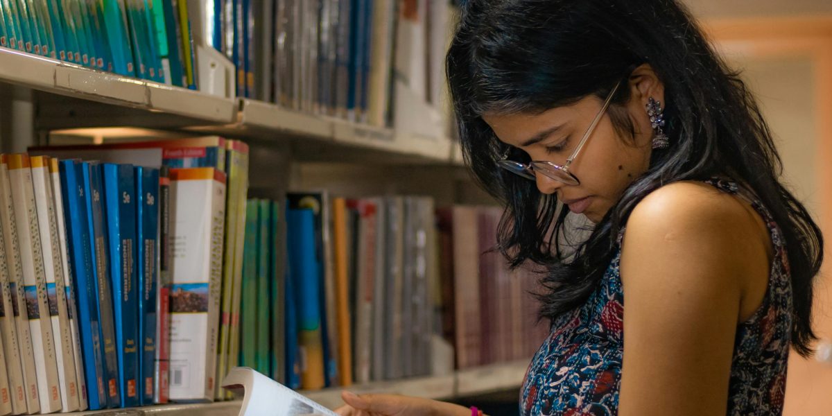 A person looking at a display of books with excitement, symbolizing the joy of discovering new reads after finishing a beloved series.