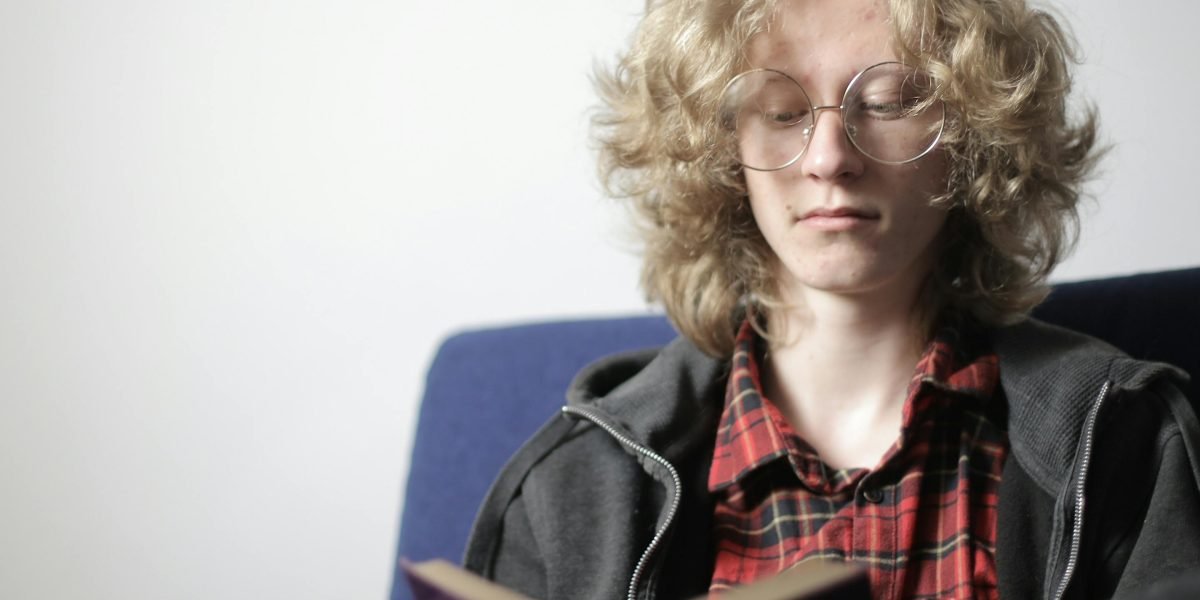 A person completely absorbed in a book, experiencing the immersive world of a completed series.
