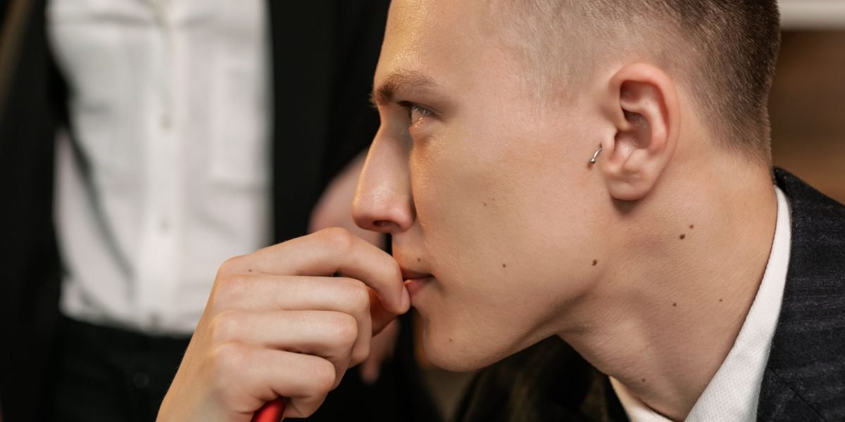 A person in a refined setting, deep in thought, facing a significant personal or romantic decision.