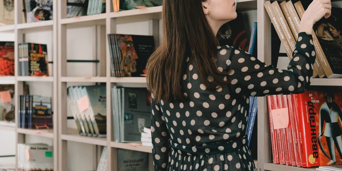 A reader confidently making a choice from a selection of books, overcoming indecision.