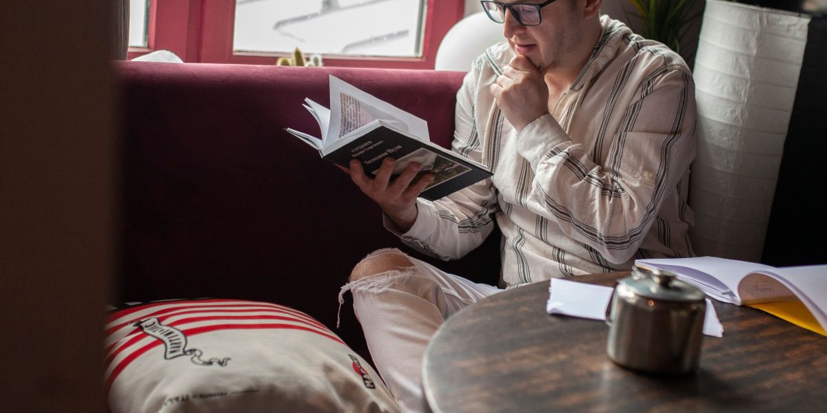 A reader absorbed in a book, reflecting on profound themes and future worlds.