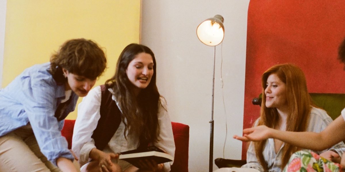 Friends enjoying a lively discussion about a book over coffee, sharing insights.